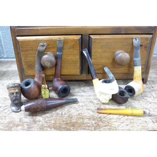 789 - A pine wall mounted pipe rack and a quantity of pipes including Meerschaum