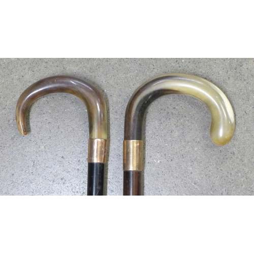 796 - Two walking sticks with horn handles and 9ct gold mounts - both monogrammed and one engraved 1933