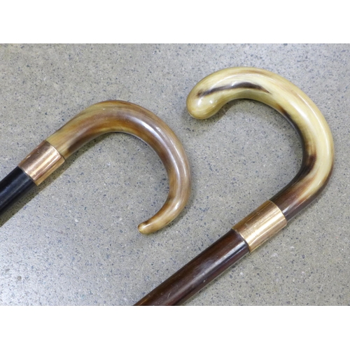 796 - Two walking sticks with horn handles and 9ct gold mounts - both monogrammed and one engraved 1933