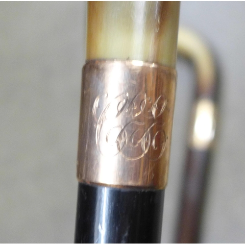 796 - Two walking sticks with horn handles and 9ct gold mounts - both monogrammed and one engraved 1933