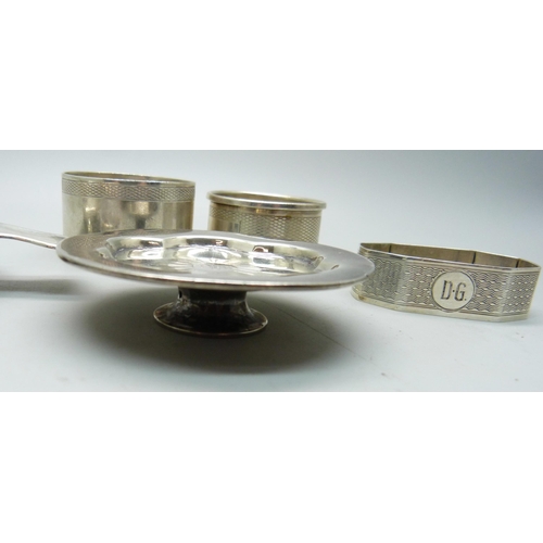 814 - Three silver napkin rings, a silver tea strainer and a Victorian silver miniature dish, 121g