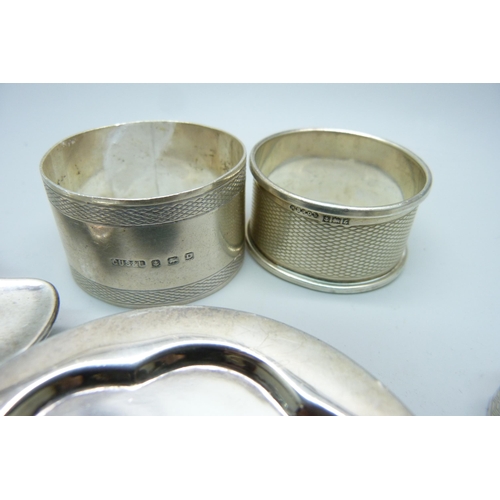 814 - Three silver napkin rings, a silver tea strainer and a Victorian silver miniature dish, 121g