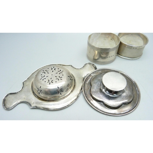 814 - Three silver napkin rings, a silver tea strainer and a Victorian silver miniature dish, 121g