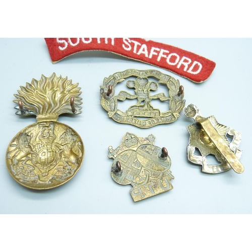 Four military badges and a South Stafford uniform arm patch