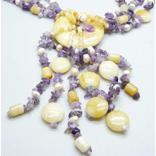 973 - A string of amethyst, pearl and hardstone beads with silver mount