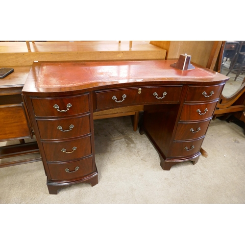 141 - A George III style mahogany and red leather topped serpentine desk