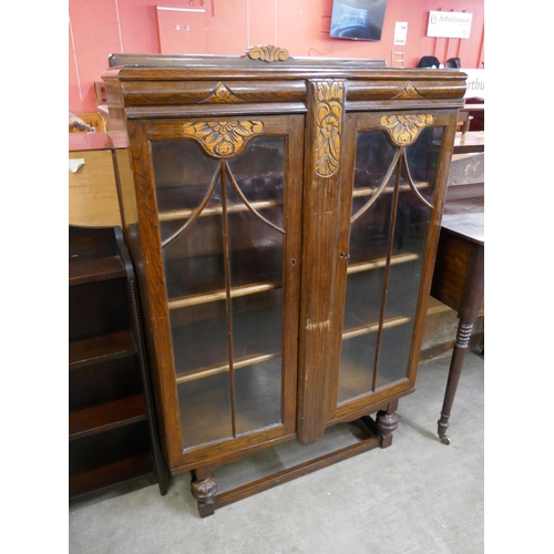 153 - An early 20th Century carved oak two door bookcase