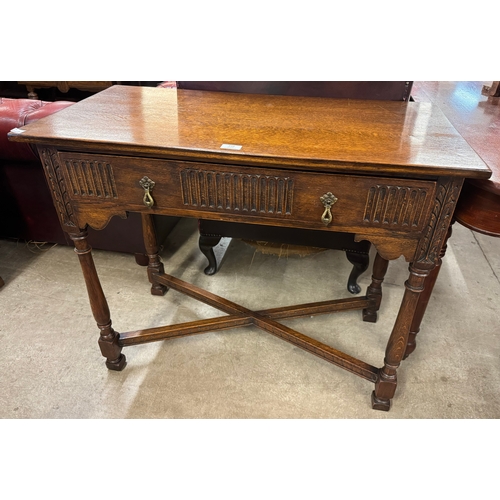 97A - A 17th Century style carved oak single drawer side table