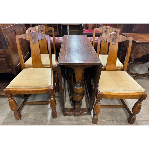 211 - An oak drop leaf table and four chairs