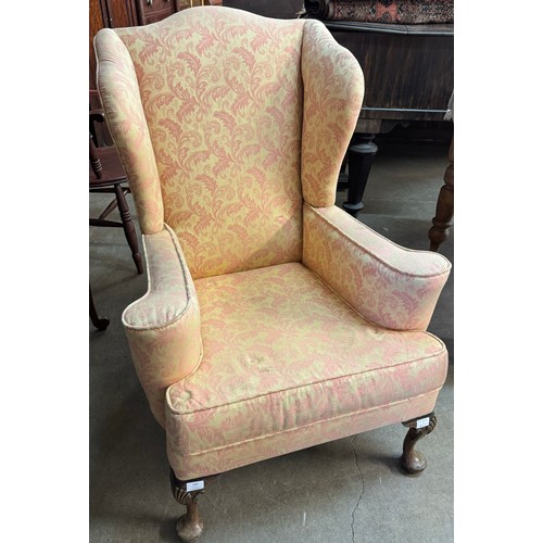 269 - An early 20th Century Queen Anne style walnut and fabric upholstered wingback armchair