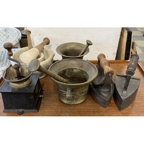 287 - A Victorian coffee grinder, four pestle and mortars and two flat irons