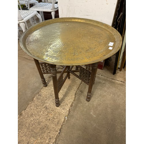 290 - An Eastern brass topped folding occasional table