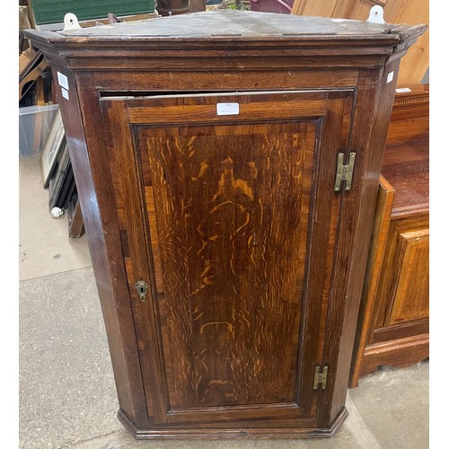 191 - A George III oak splay front wall hanging corner cupboard