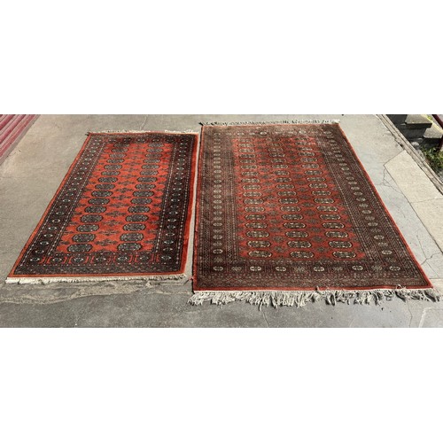 281 - Two terracotta ground rugs, 200cm x 124cm and 165cm x 95cm