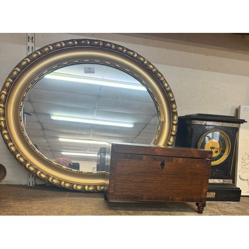 395 - An oval gilt framed mirror, an early Victorian rosewood tea caddy and a French black slate and marbl... 