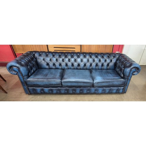 1 - A blue leather four seater Chesterfield settee