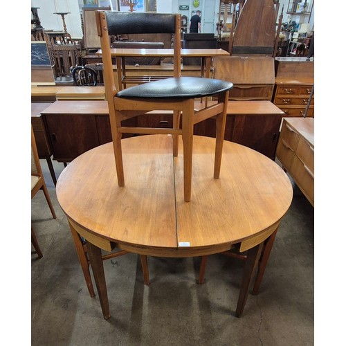 27 - A teak circular extending dining table and four chairs