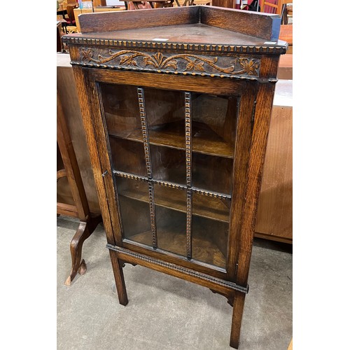 161 - An early 20th Century carved oak corner cabinet
