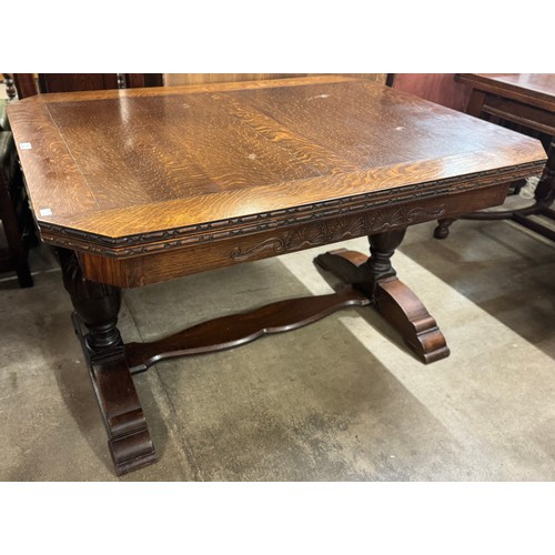 150 - An early 20th Century carved oak draw-leaf table