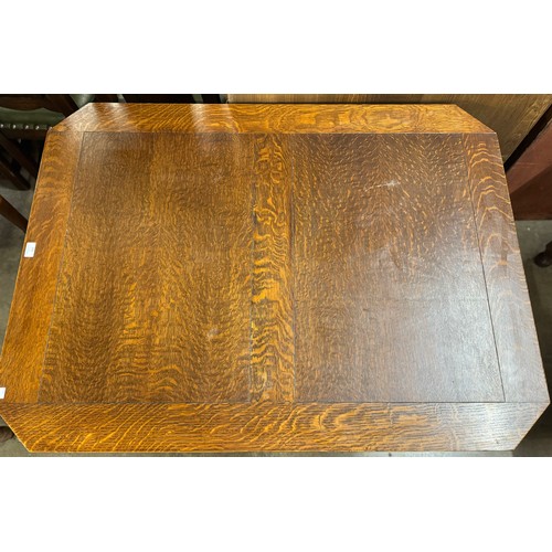 150 - An early 20th Century carved oak draw-leaf table