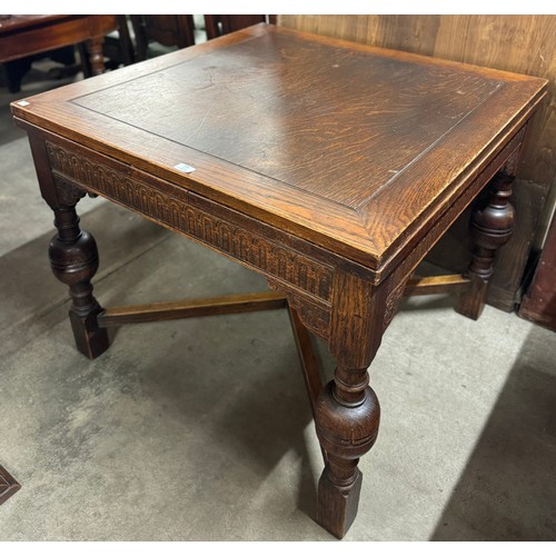 151 - An early 20th Century carved oak draw-leaf table
