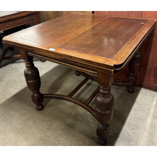 152 - An early 20th Century carved oak draw-leaf table