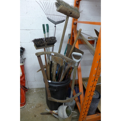 2196 - A large quantity of garden tools including a watering can, a rake, long reach clippers, a pickaxe, s... 