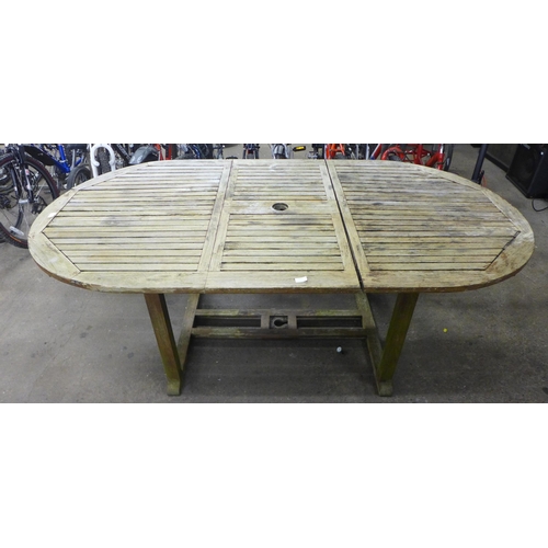 2147 - An oval Teak Garden table - 210cm when extended