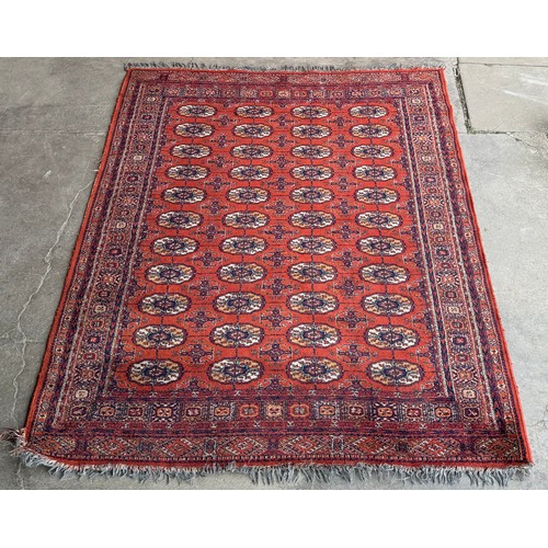 190 - A terracotta ground rug, 240cm x 175cm