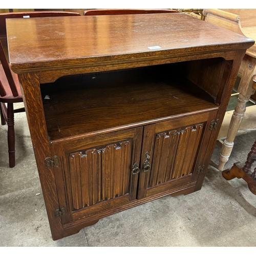 231 - A carved oak linenfold side cabinet