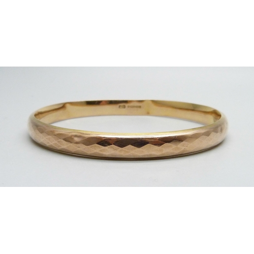 1024 - A 9ct gold faceted bangle, 11.8g, dented