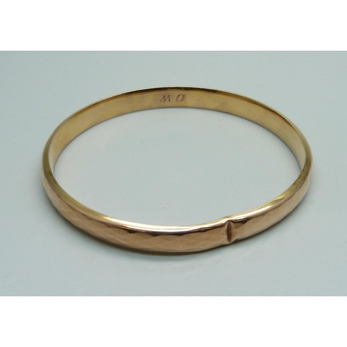 1024 - A 9ct gold faceted bangle, 11.8g, dented