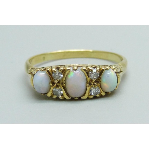 1032 - A yellow metal ring set with three opals and diamonds, 3.9g, Q