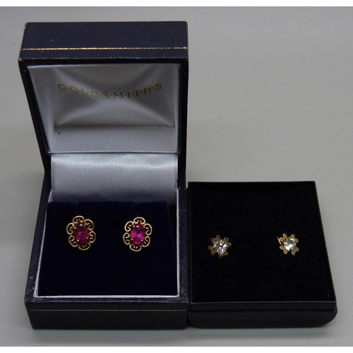 1034 - A pair of 9ct gold red stone earrings and a pair of yellow metal white stone earrings