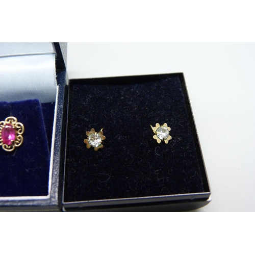 1034 - A pair of 9ct gold red stone earrings and a pair of yellow metal white stone earrings