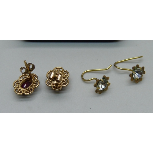 1034 - A pair of 9ct gold red stone earrings and a pair of yellow metal white stone earrings