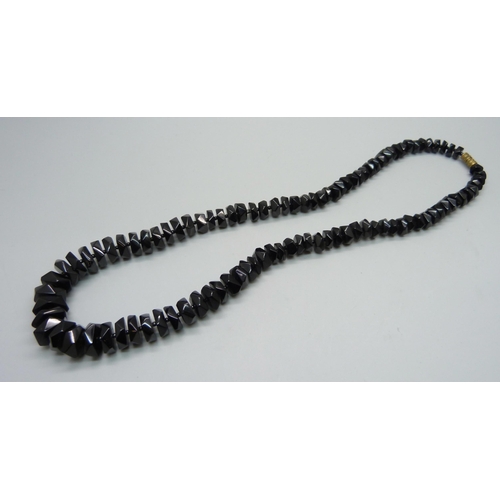 1036 - A string of faceted Whitby jet beads