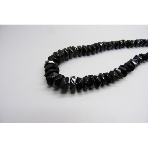 1036 - A string of faceted Whitby jet beads