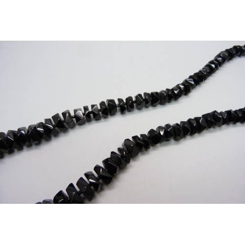 1036 - A string of faceted Whitby jet beads