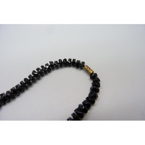 1036 - A string of faceted Whitby jet beads