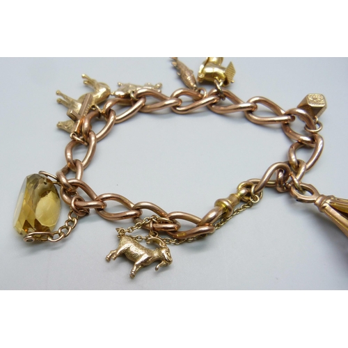 1051 - A 9ct gold charm bracelet, 63.3g, each link marked, fish charm not marked, all others hallmarked or ... 