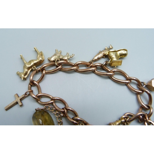 1051 - A 9ct gold charm bracelet, 63.3g, each link marked, fish charm not marked, all others hallmarked or ... 