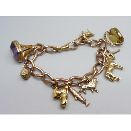 1051 - A 9ct gold charm bracelet, 63.3g, each link marked, fish charm not marked, all others hallmarked or ... 