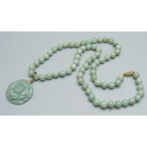 1105 - A carved jade pendant on a necklace with a 14k clasp