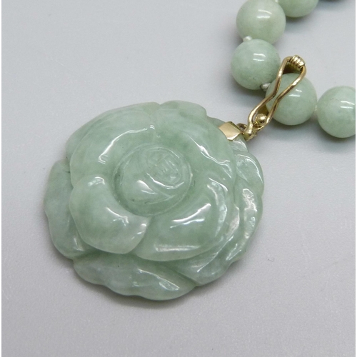 1105 - A carved jade pendant on a necklace with a 14k clasp