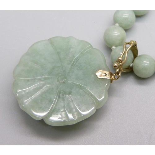 1105 - A carved jade pendant on a necklace with a 14k clasp