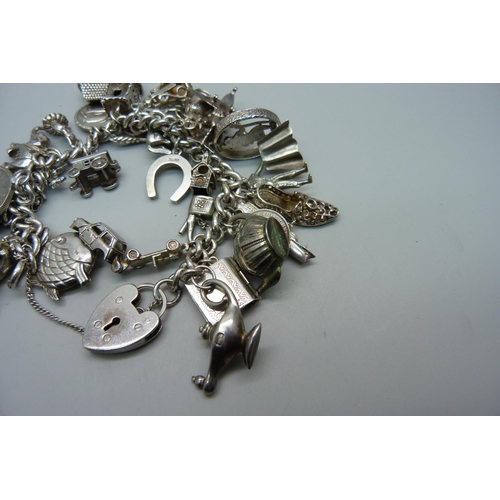 1129 - A silver charm bracelet, 114g