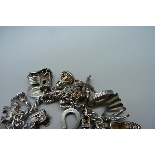 1129 - A silver charm bracelet, 114g