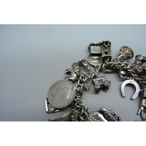 1129 - A silver charm bracelet, 114g