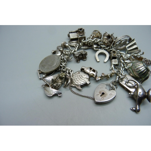 1129 - A silver charm bracelet, 114g